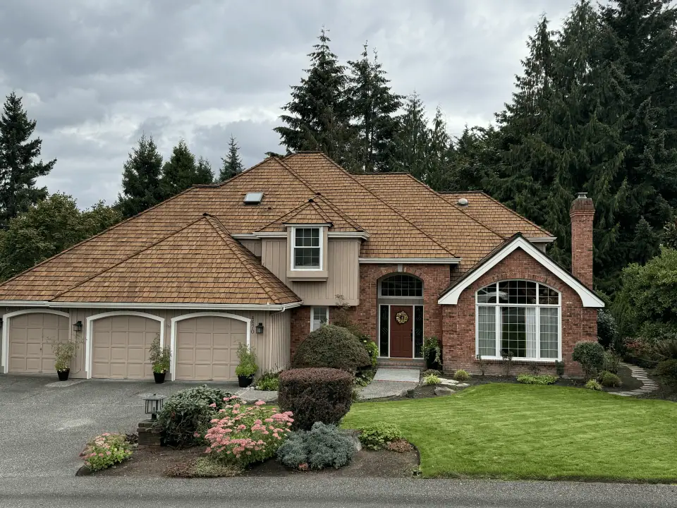 Restored honey-tone cedar shake roof on a red brick house